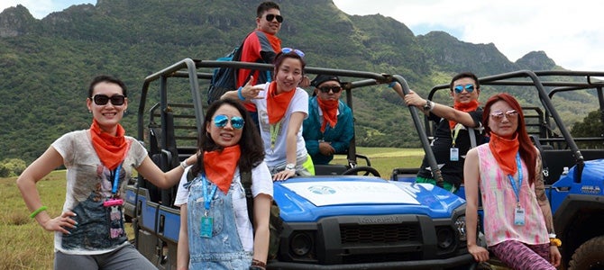 Nu Skin Sales Leaders from Greater China pose in front of off-road vehicles while they explore famous movie sets in Hawaii.